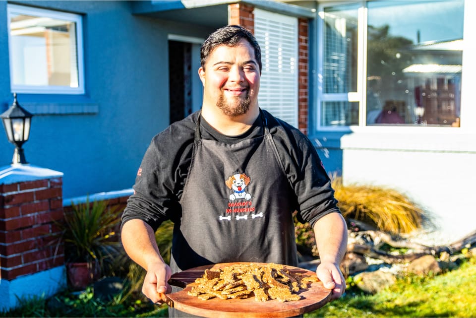 Bradley outside holding a tray of homemade dog treats