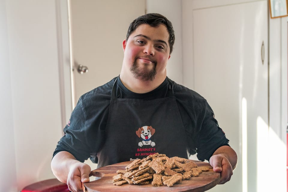 Bradley in a kitchen holding a tray of dog treats
