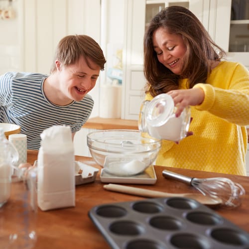 A woman and a young man baking together in a kitchen